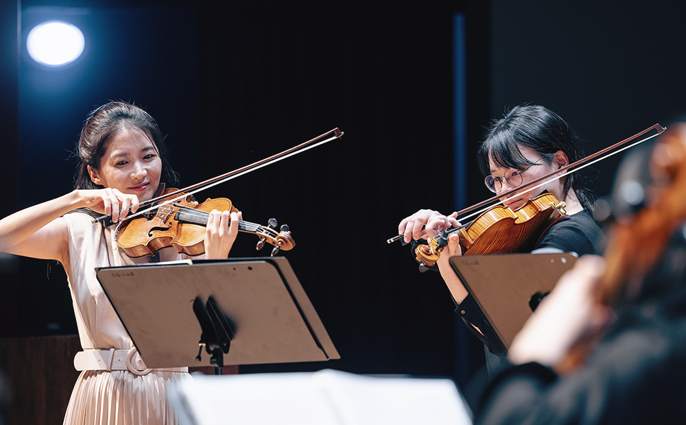 Violinist Soojin Han (left), a hy-classic mentor, performing with scholarship students