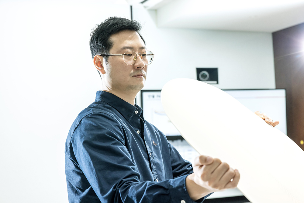 Kyungwon Kim inspects the surface of a recycled pad sample